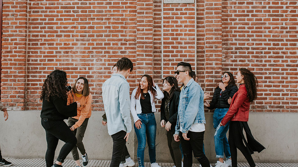 a group of people standing in front of a brick building