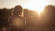 a person standing in front of trees in the sun