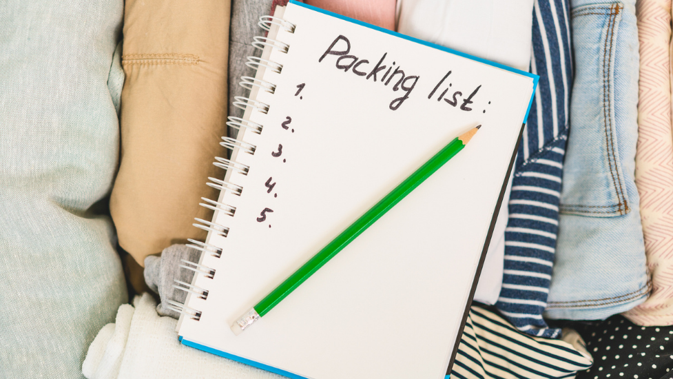 a note book on top of folded clothes