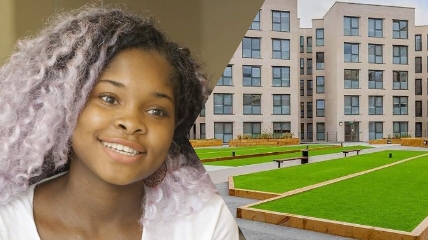 a young girl who is smiling at the camera and building behind