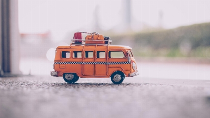 a close up of a toy car with suitcases on the roof