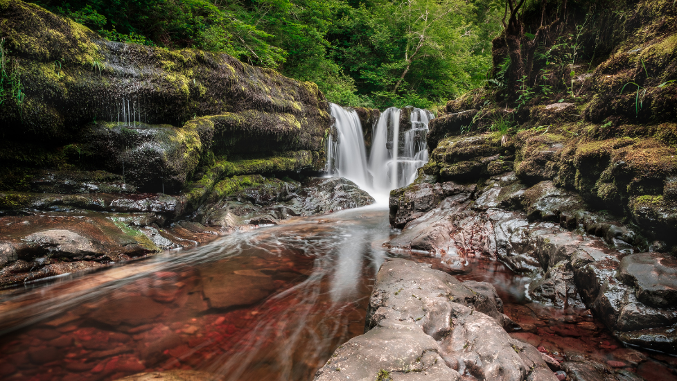 a large waterfall over a rocky cliff