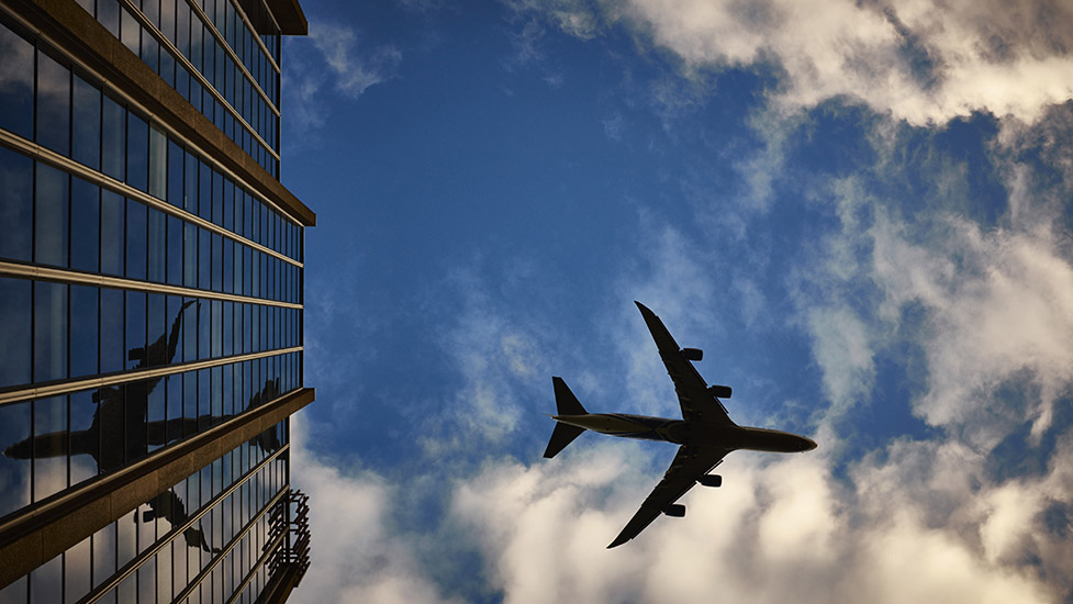 a large airplane flying high up in the air on a cloudy day