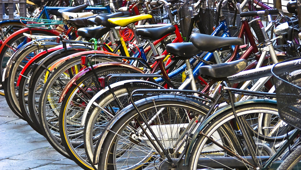 a row of parked motorcycles sitting next to a bicycle