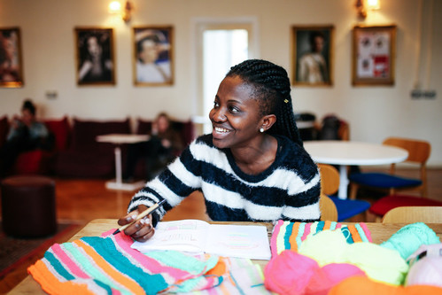 a person sitting at a table with knitting