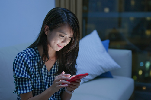 a woman sitting at a table using a phone