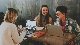 a group of people sitting at a table using a laptop