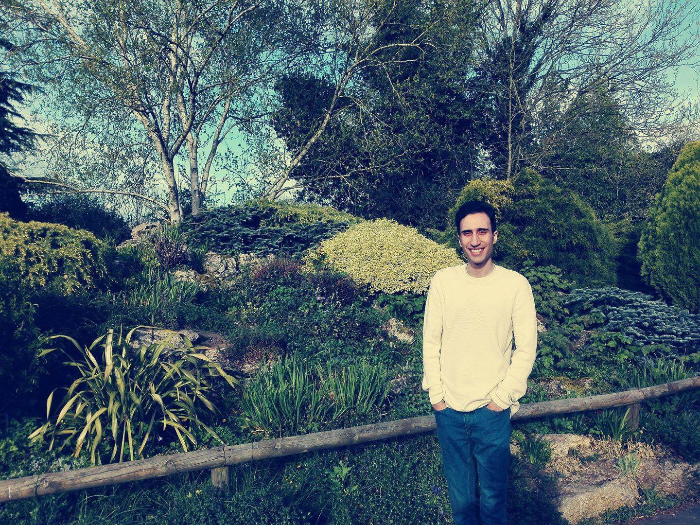 a man standing in front of a tree posing for the camera