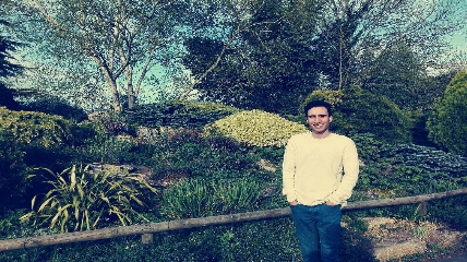 a man standing in front of a tree posing for the camera