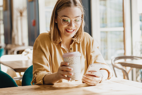 a woman sitting at a table with a cup of coffee