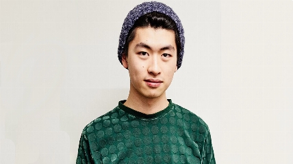 a young man wearing a green shirt