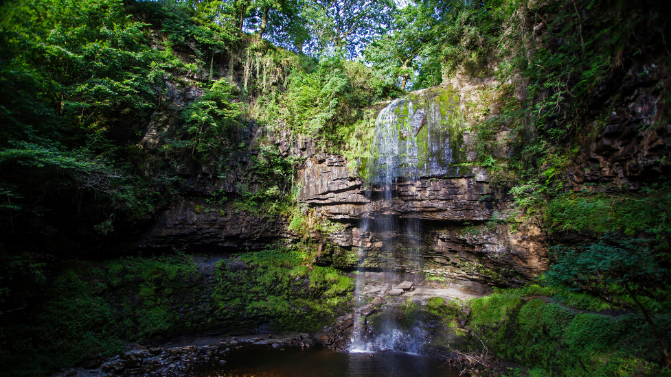 a large waterfall over a body of water